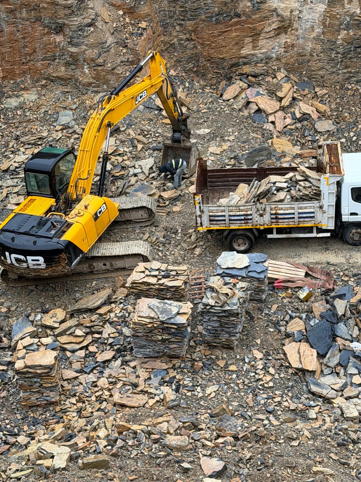 Ocakta ekskavatör ve kamyonla doğal taş üretimi